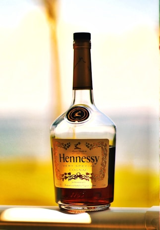 a bottle of hennesy is sitting on a window sill