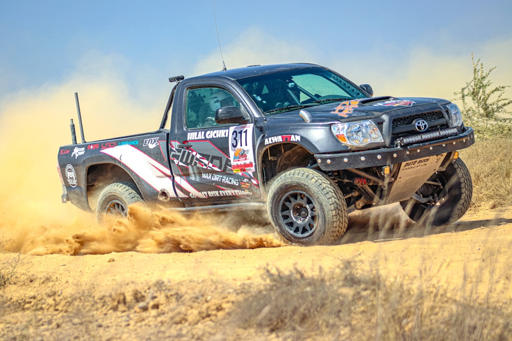 a truck driving on a dirt road in the desert