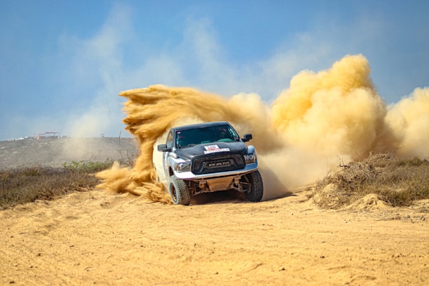 a white truck driving down a dirt road