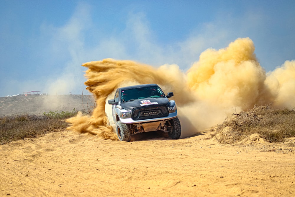 a white truck driving down a dirt road