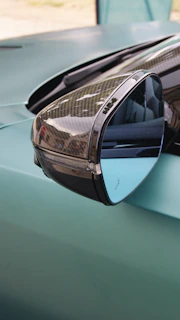 Close-up of a gently used car side mirror with subtle reflections showing its clear glass and intact housing.