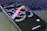 A smartphone lies on a laptop keyboard with the screen displaying swirling text that reads 'SAY MORE' and 'THREADS' in colorful letters. The Instagram logo is visible at the bottom of the phone's screen.