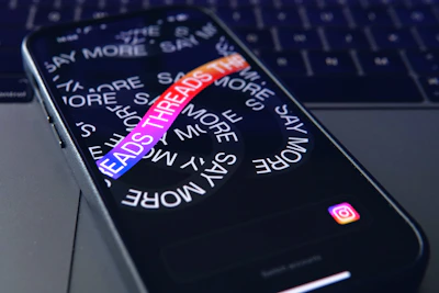 a close up of a cell phone with a keyboard in the background