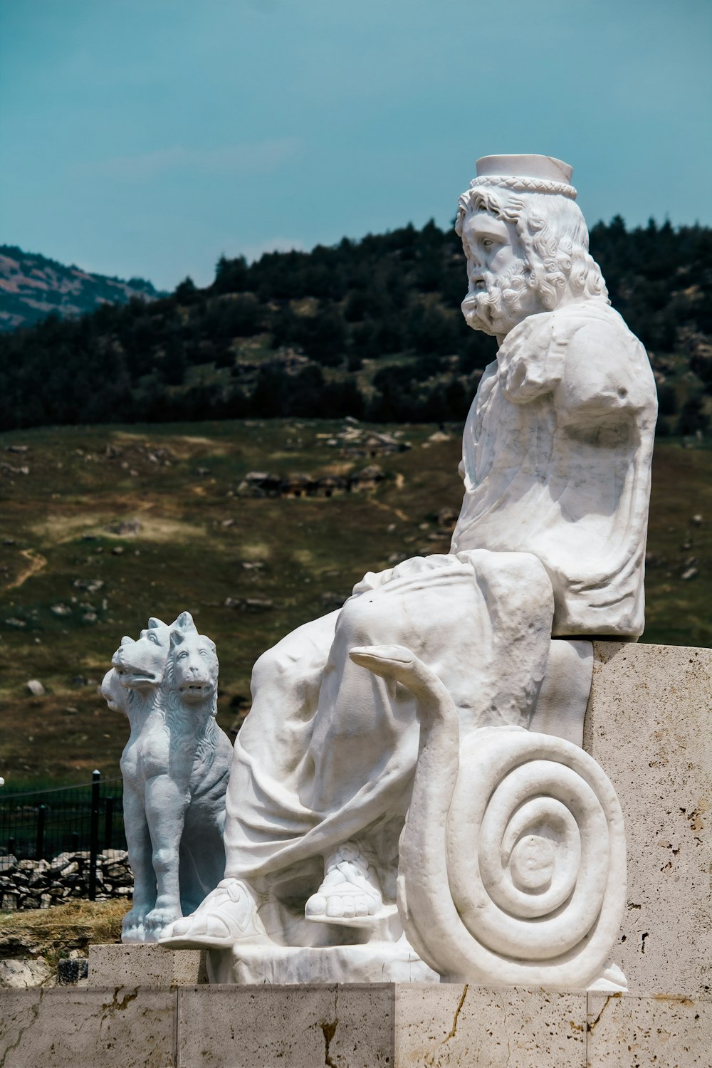 a statue of a man sitting on a bench next to a dog