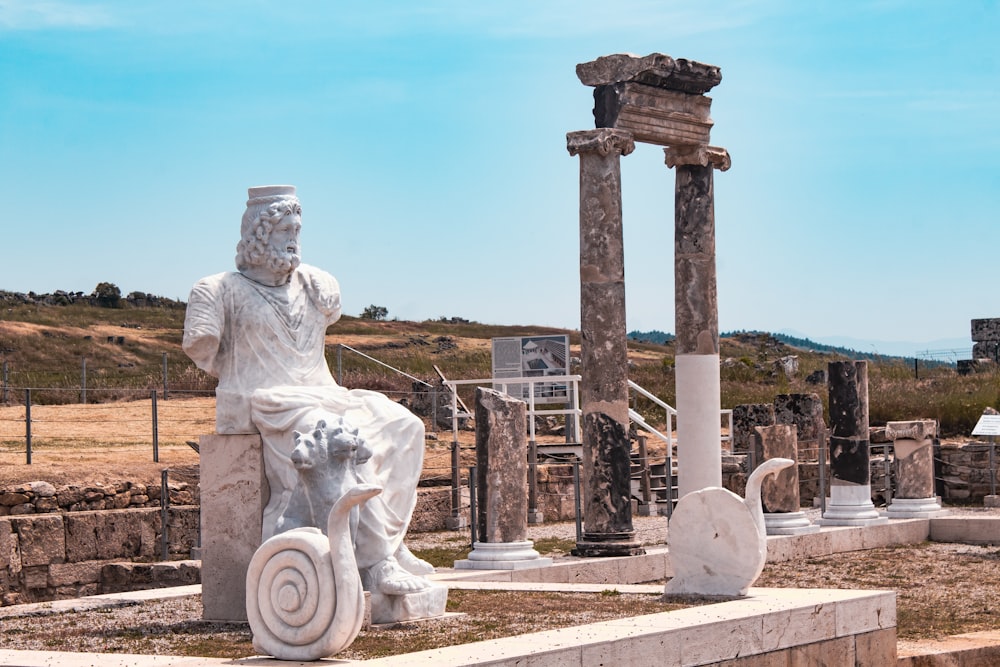 a statue of a man sitting on top of a stone bench