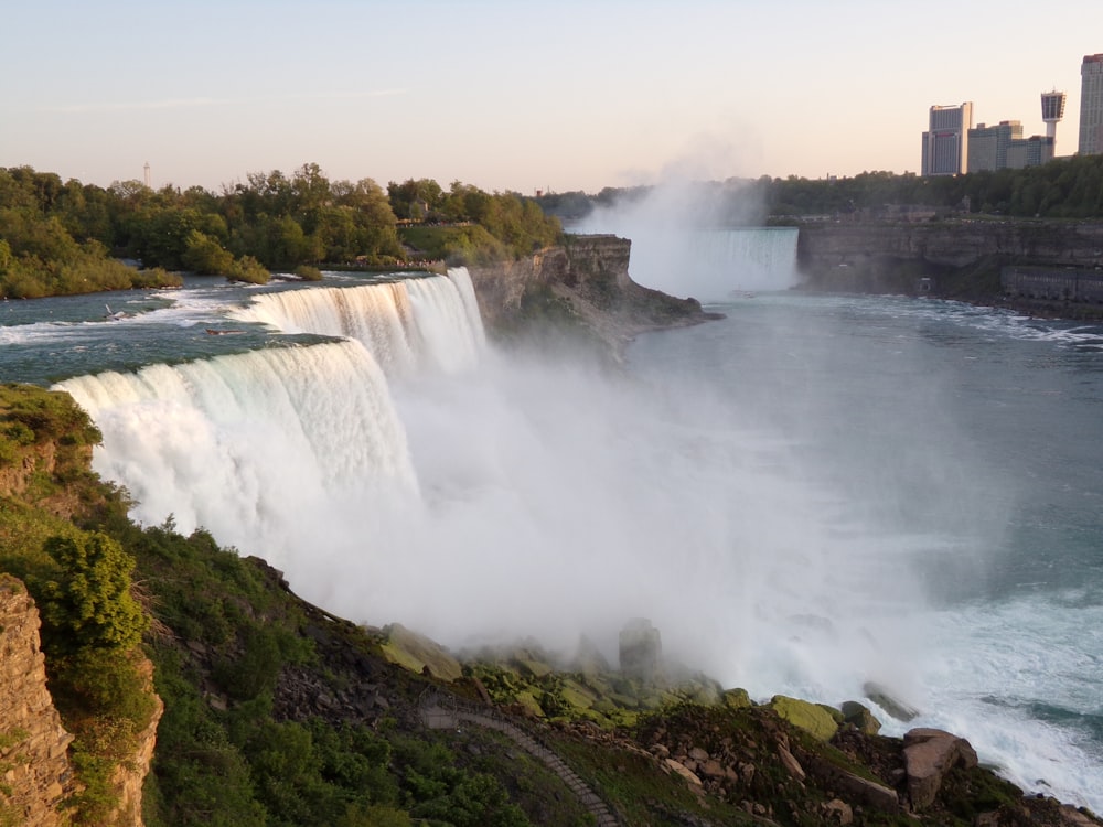 a view of a waterfall and a city in the background