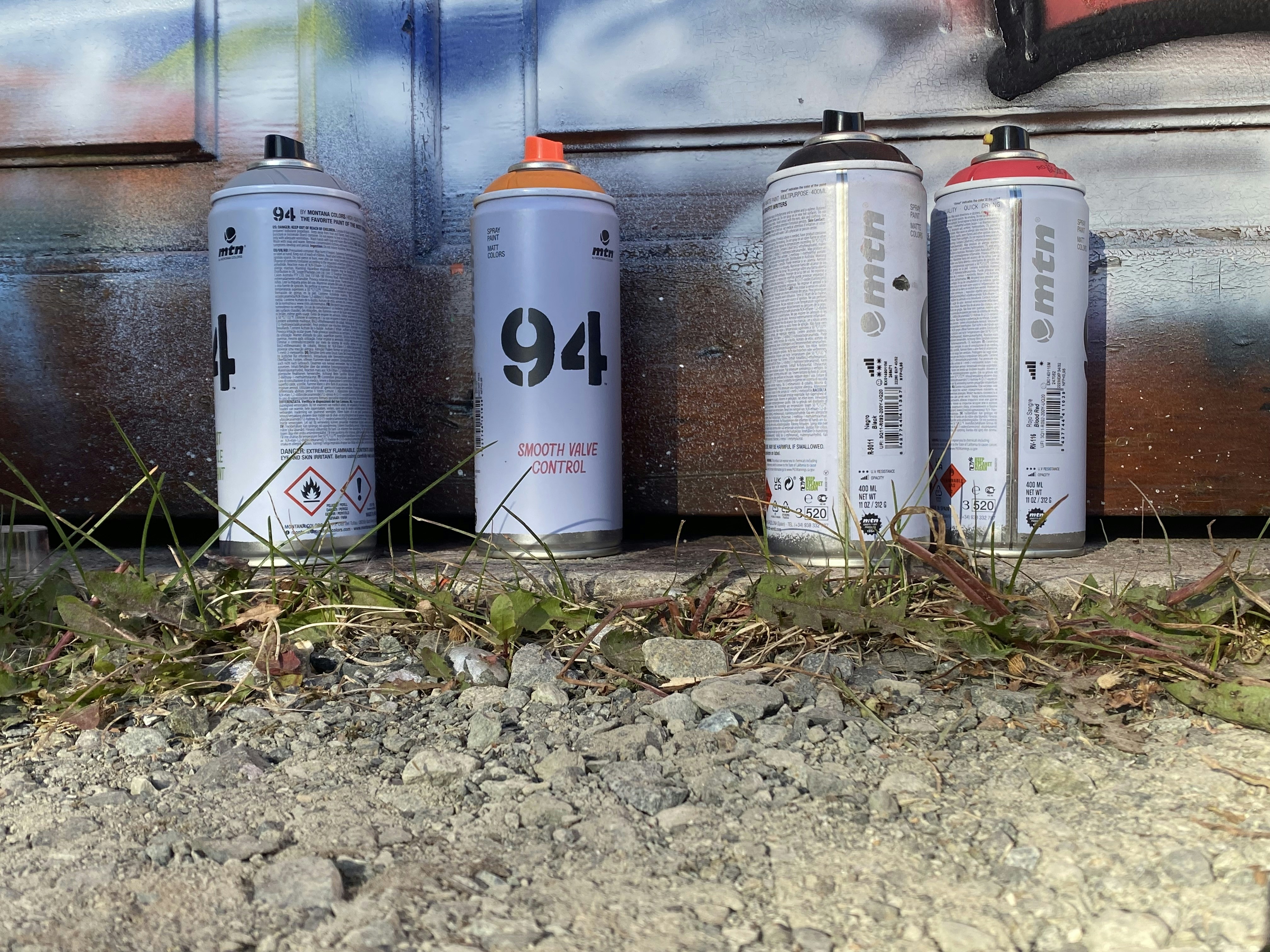 three cans of spray paint sitting next to each other