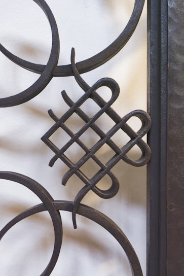 a close up of a metal gate with a design on it