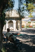 a man sitting on a bench in front of a building