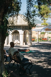 a man sitting on a bench in front of a building