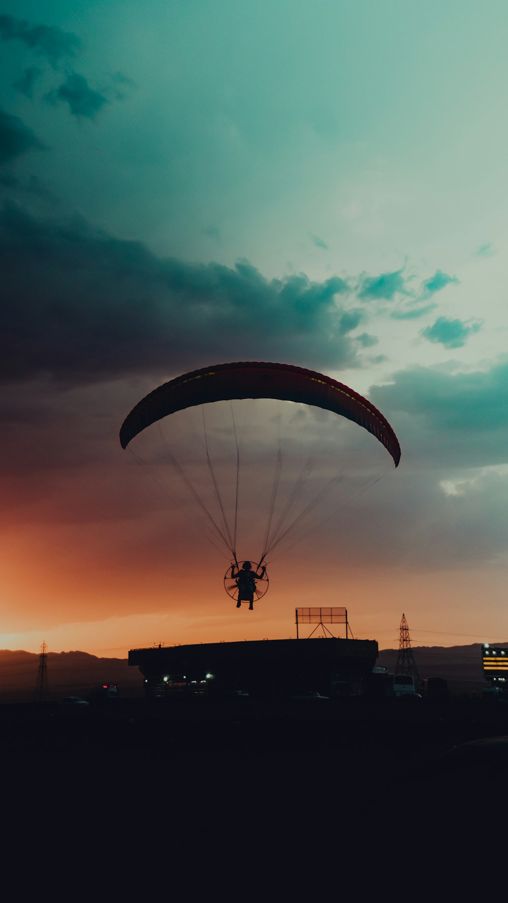 a person is parasailing in the sky at sunset