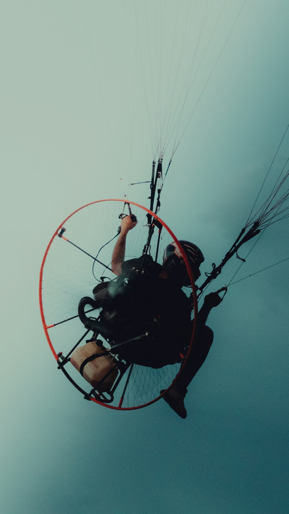 a man flying through the air on top of a parachute