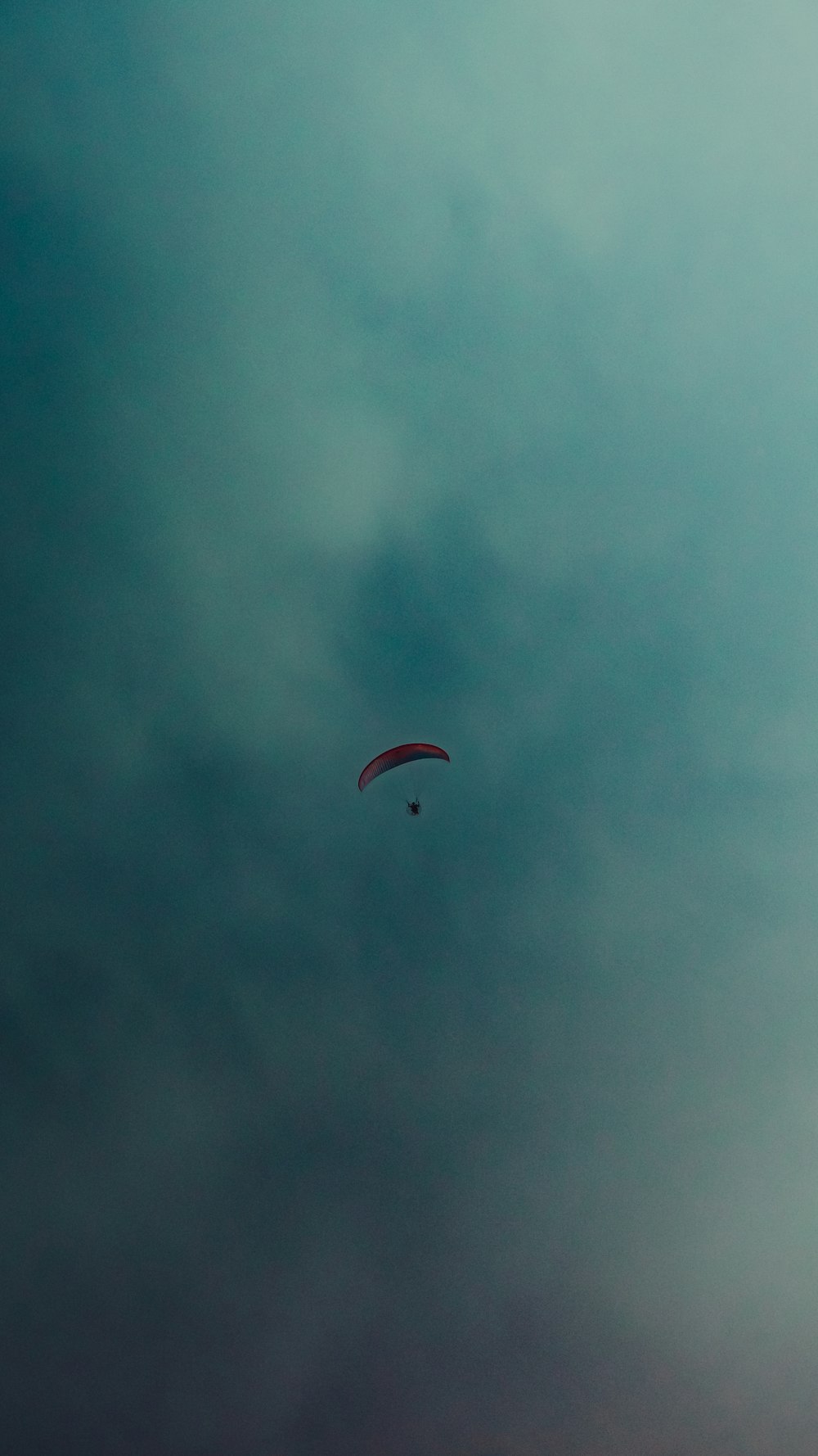 a paraglider is flying through a cloudy sky