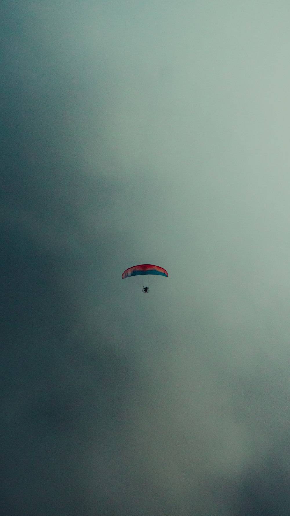 a parasailer is flying through a cloudy sky