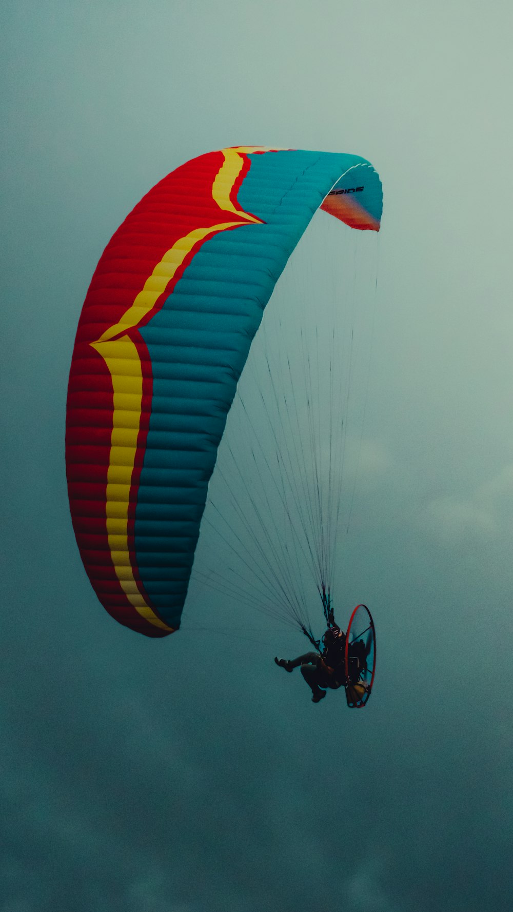 a person is parasailing on a cloudy day