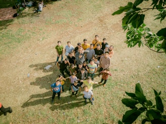 a group of people standing on top of a grass covered field