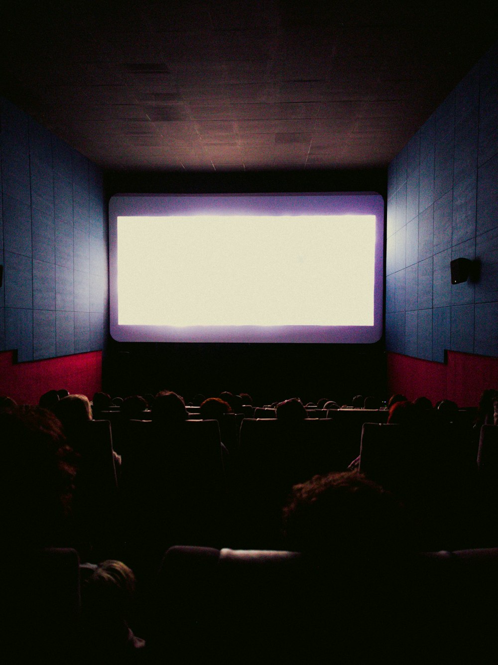 a large screen in a dark room with people watching it