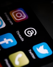 a close up of a cell phone with different social icons