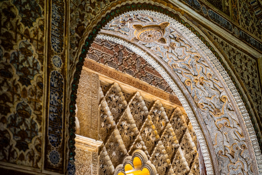 a yellow traffic light in front of a decorative wall