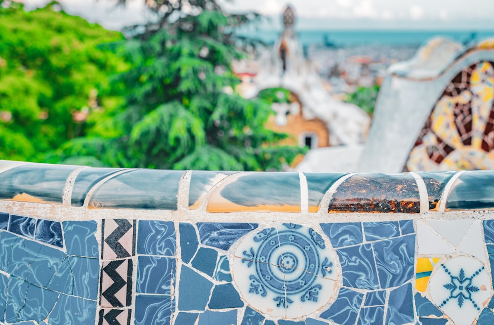 a close up of a tiled wall with trees in the background