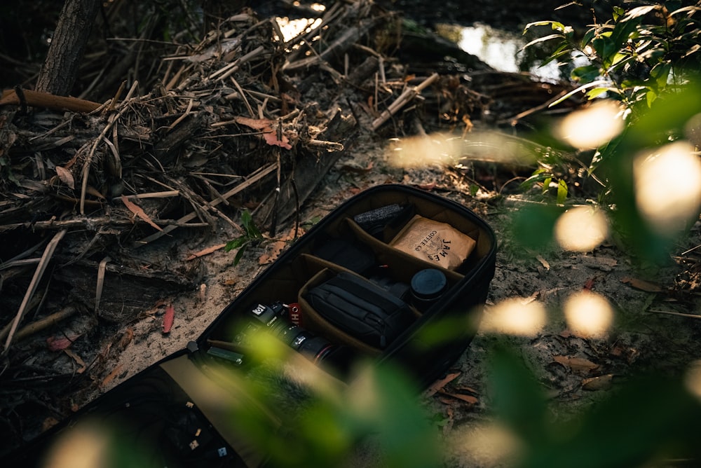 an open suitcase sitting on the ground in the woods