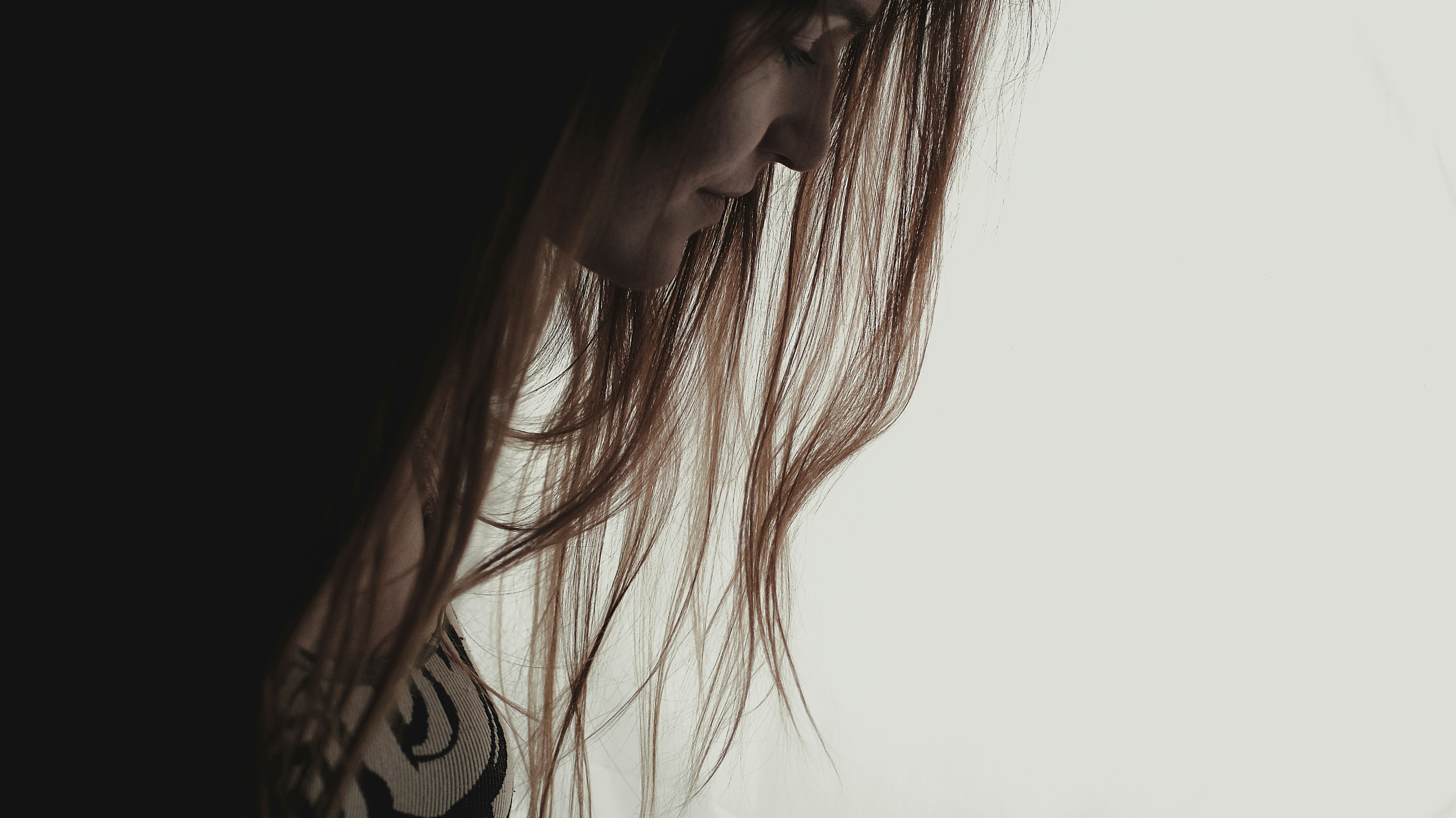 a woman with long hair standing in front of a window