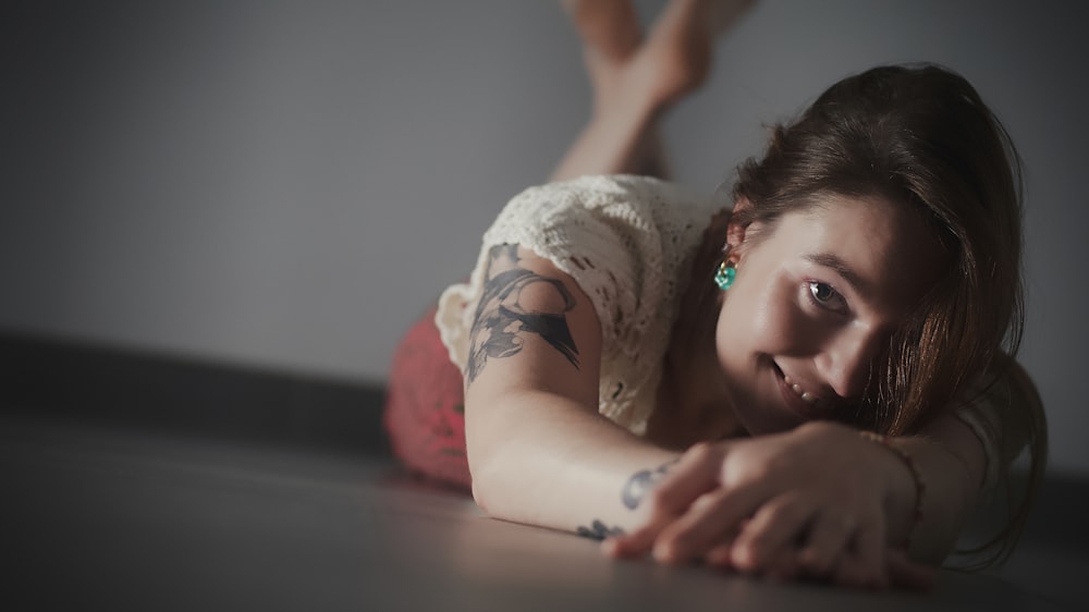 a woman with tattoos laying on the floor