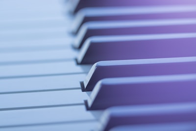 Close-up view of piano keys with a soft focus and a gentle blur effect. The lighting creates a serene and tranquil atmosphere.