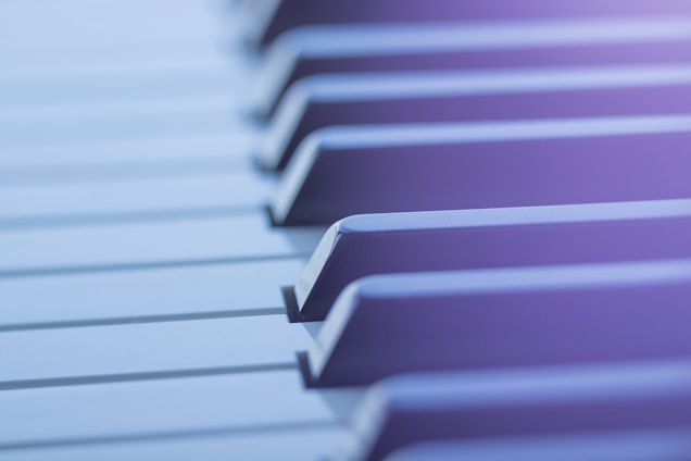 Close-up view of piano keys with a soft focus and a gentle blur effect. The lighting creates a serene and tranquil atmosphere.