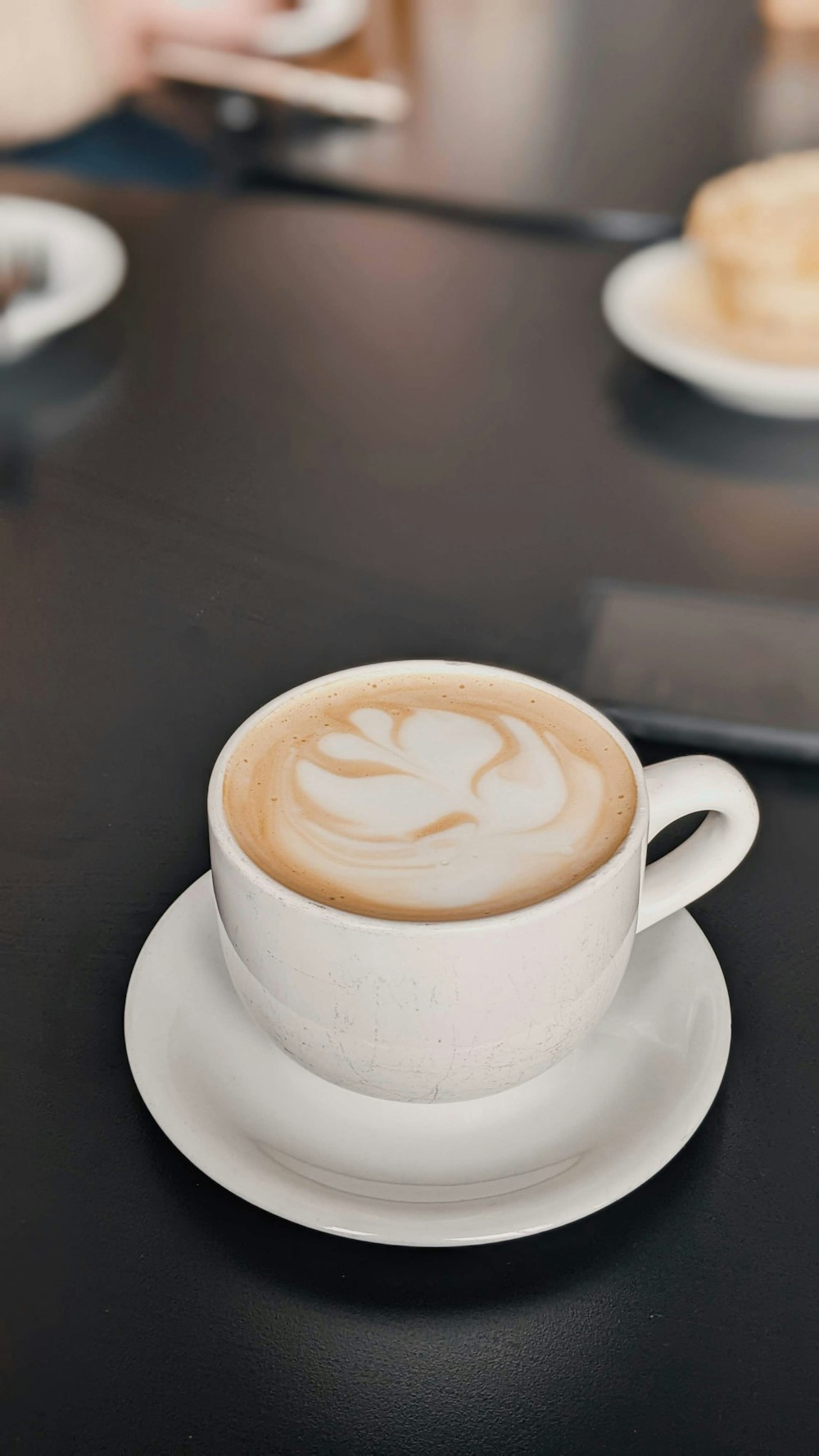 a cup of coffee on a saucer on a table