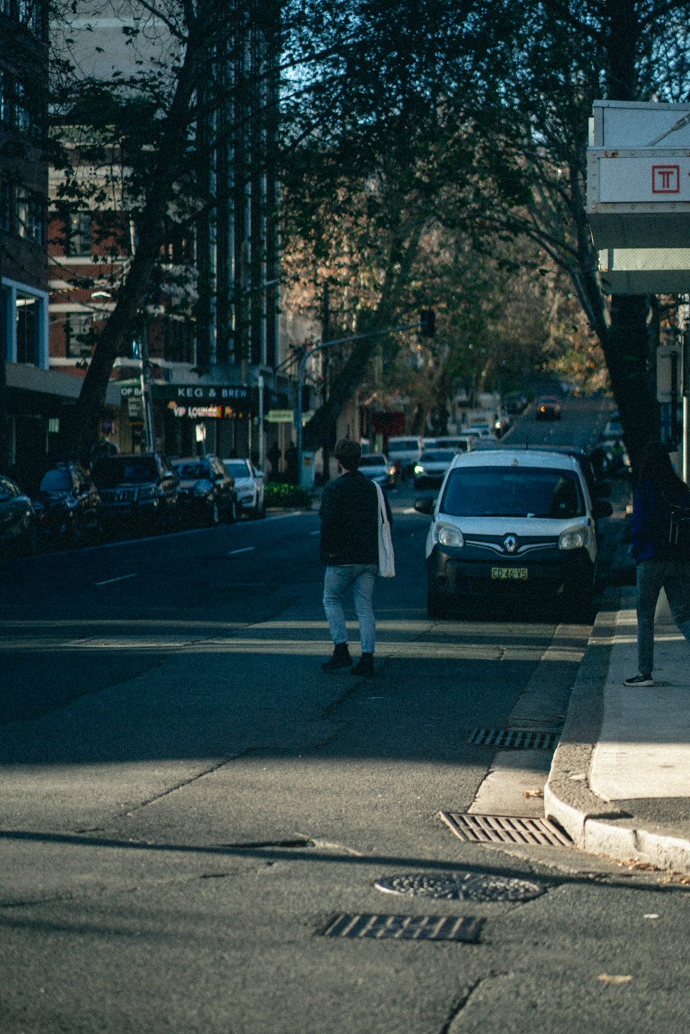 a group of people walking down a street next to a parking meter