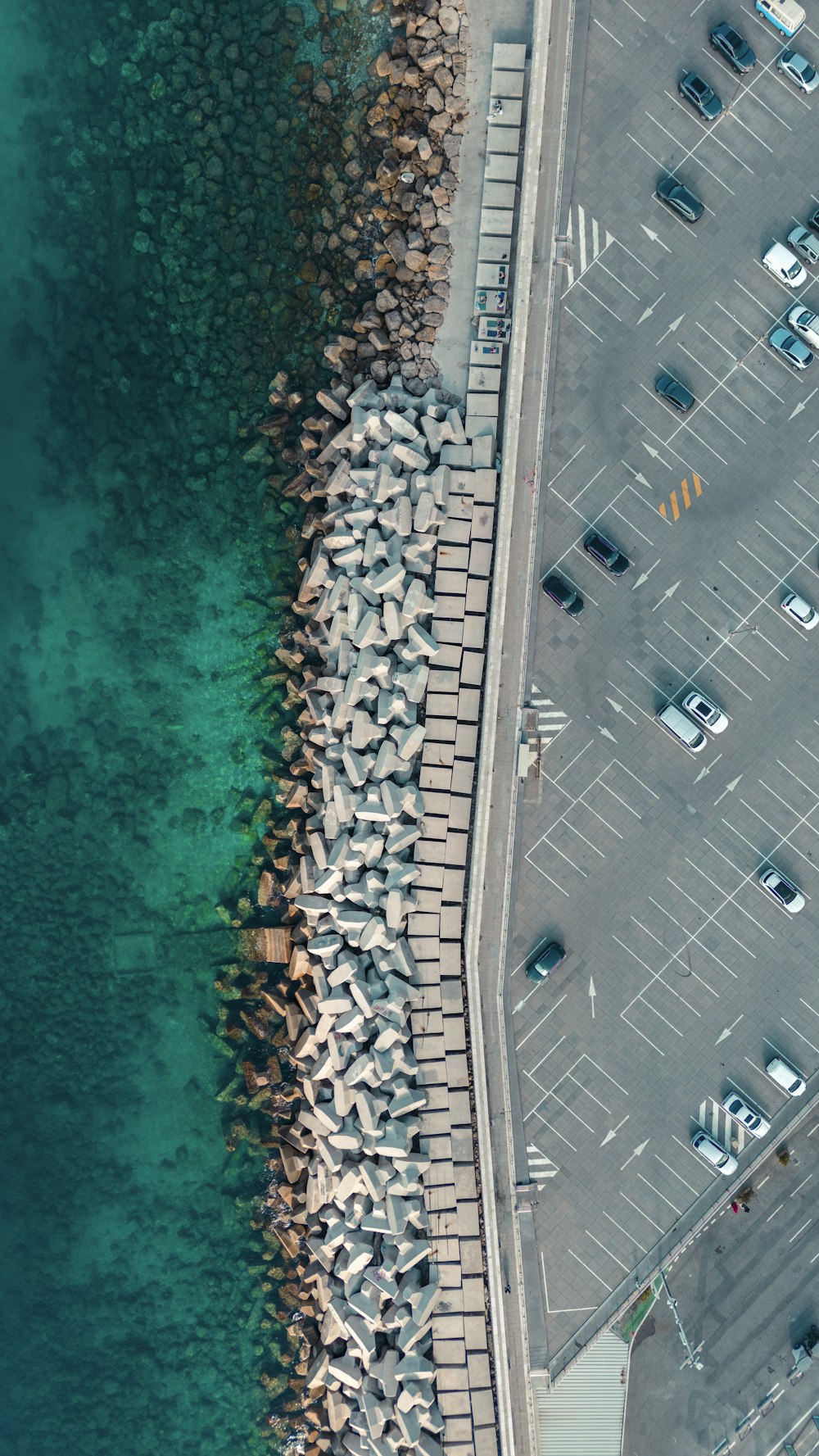 an aerial view of a parking lot next to a body of water