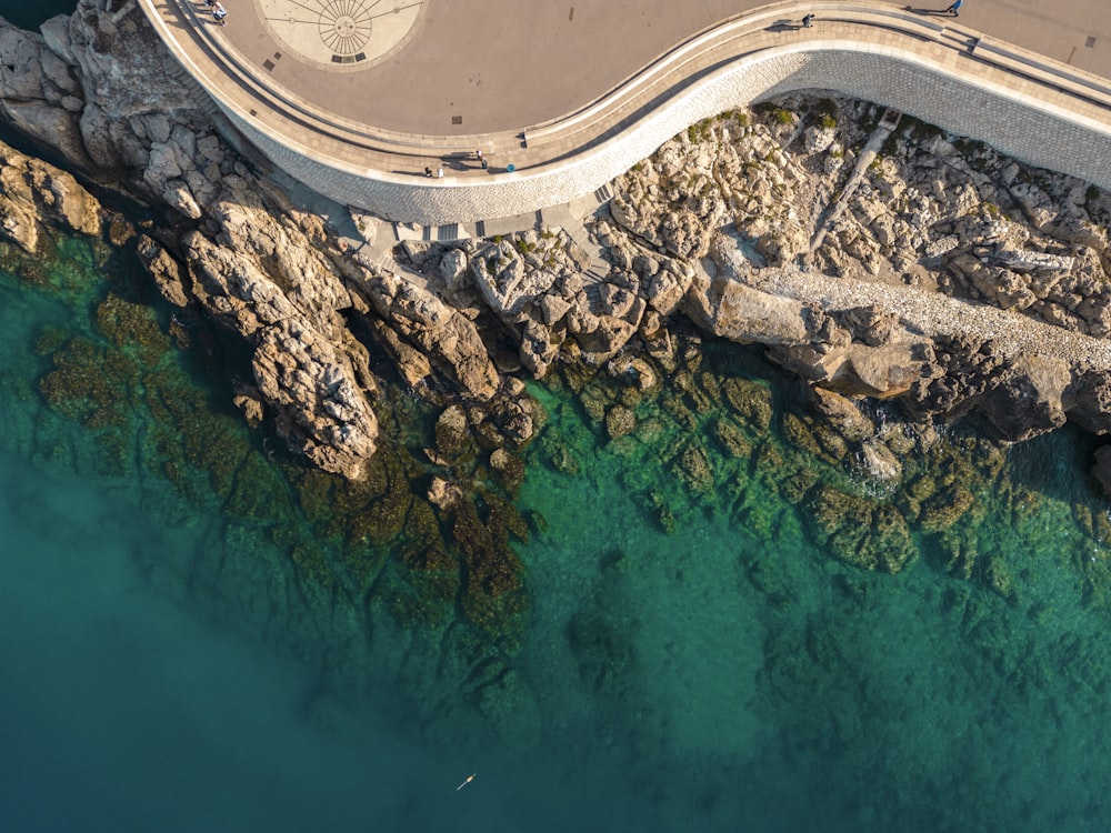 an aerial view of a road next to a body of water