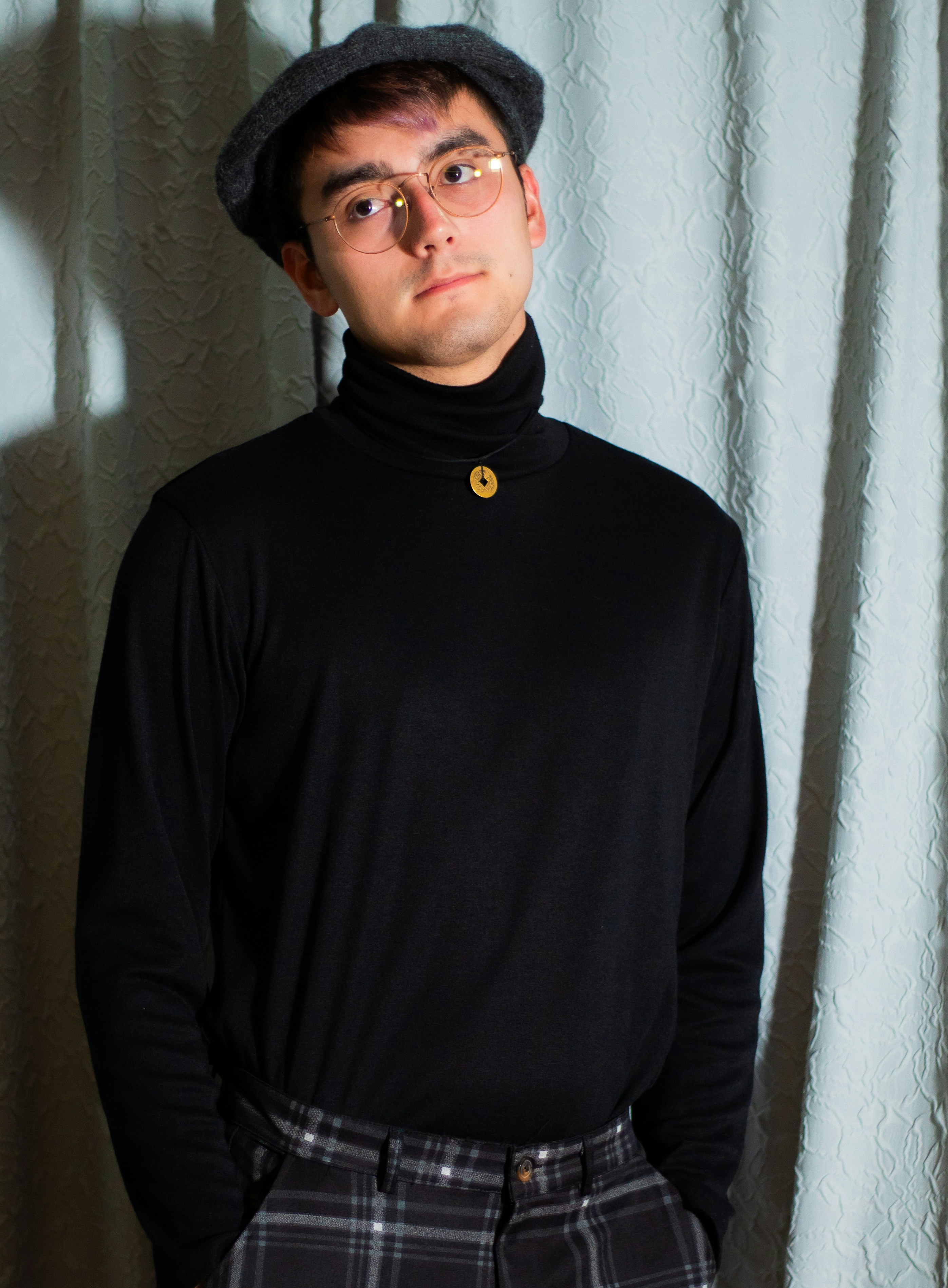 ein Mann in schwarzem Pullover und karierter Hose