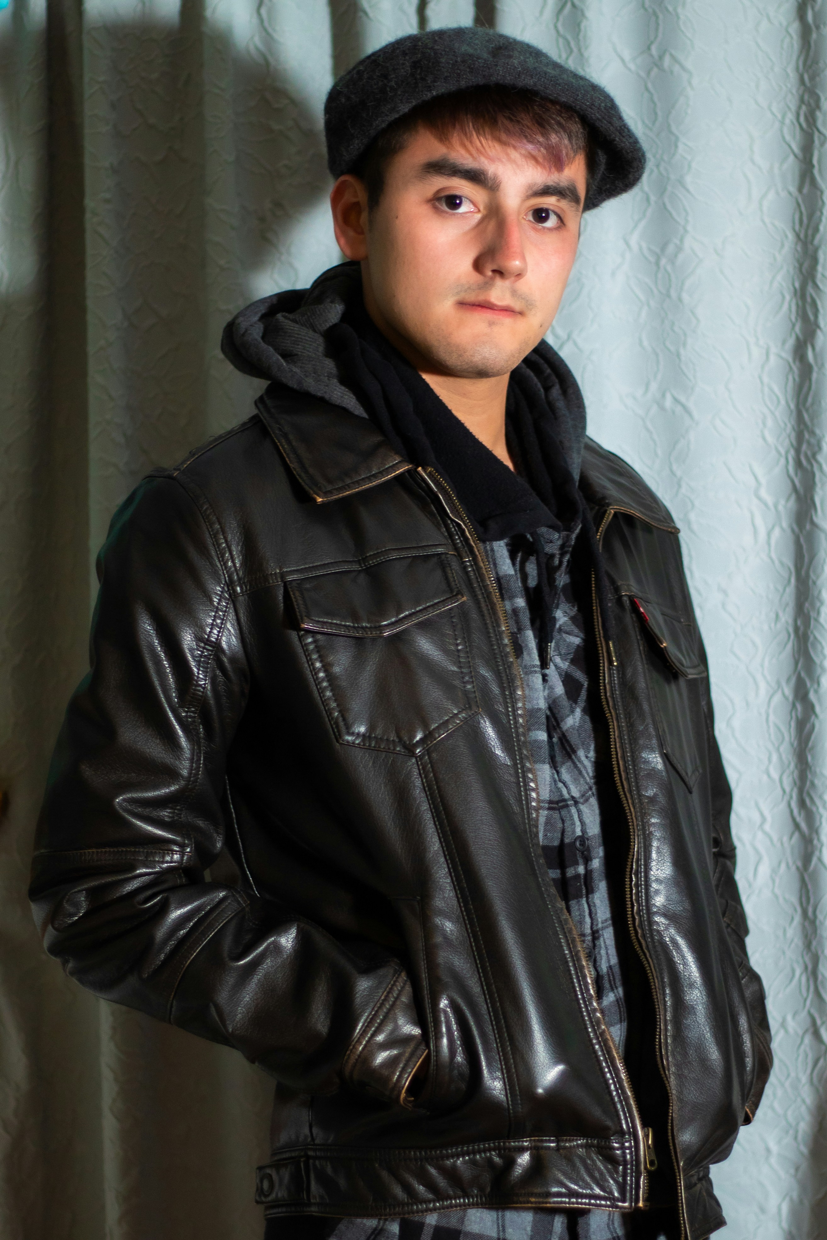 a man in a leather jacket and hat