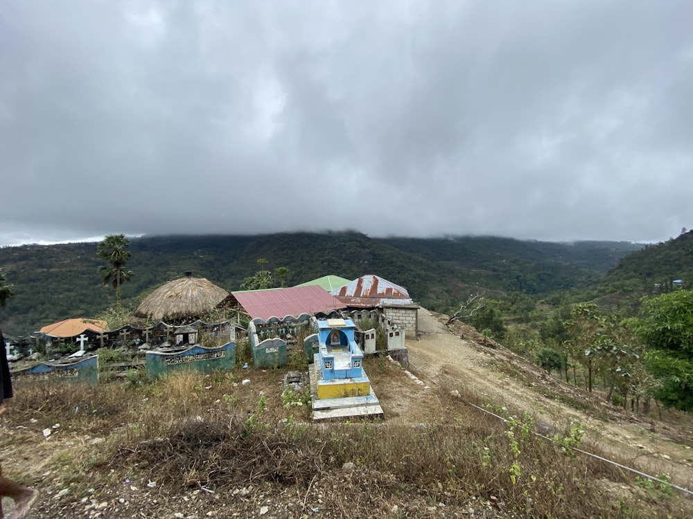 a dirt road in front of a small village