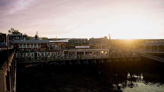 Cozy seafood restaurant interior with fishermen's nets and fresh catch displays at sunset.