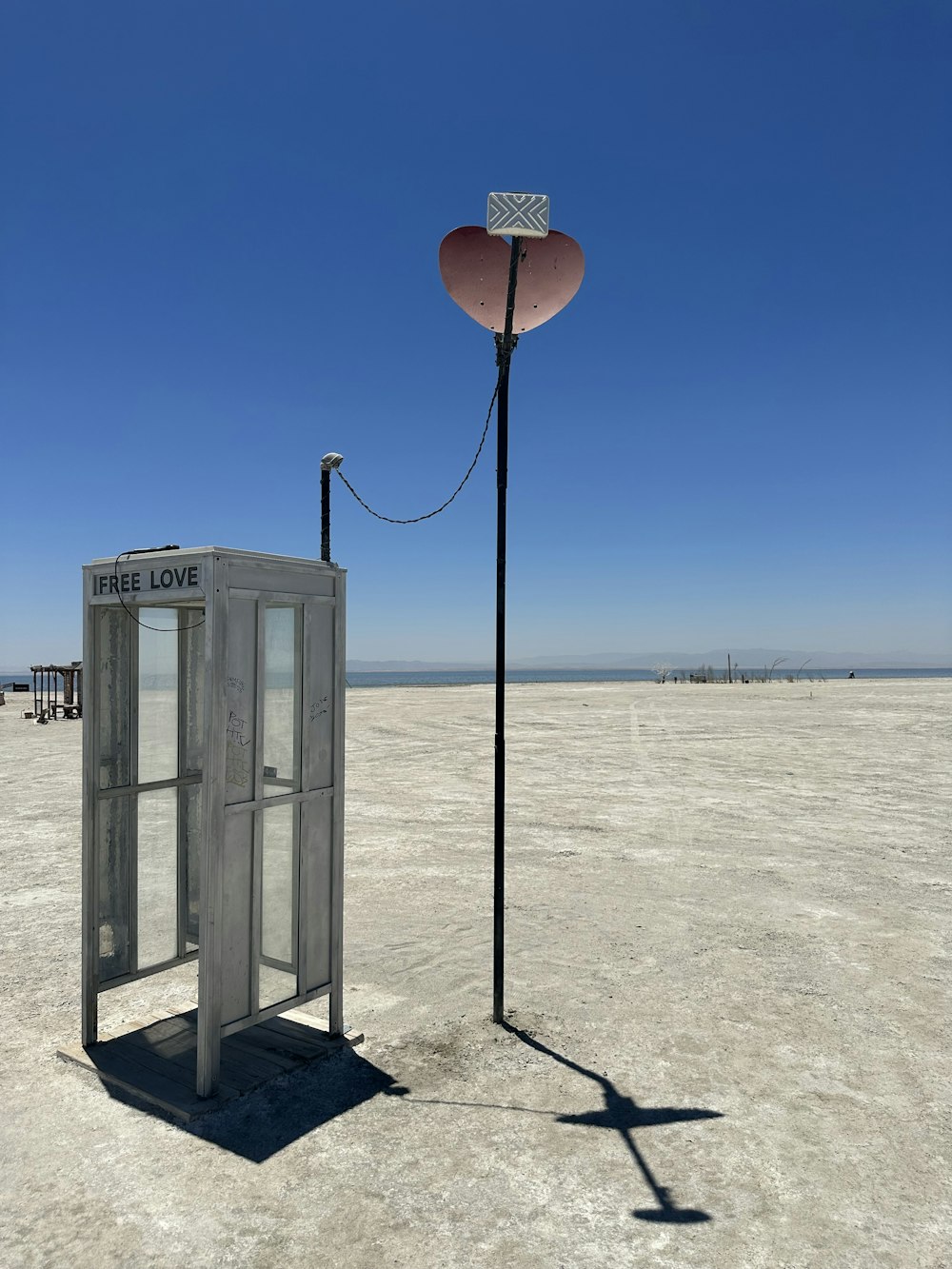 a phone booth sitting in the middle of a desert