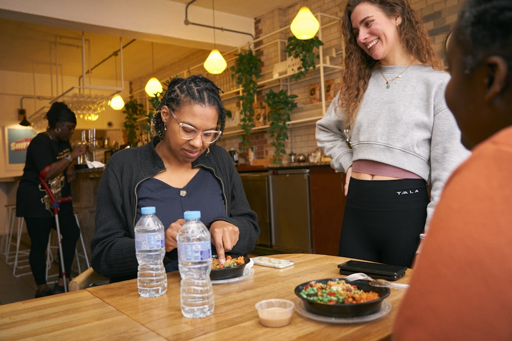 a woman sitting at a table with a plate of food