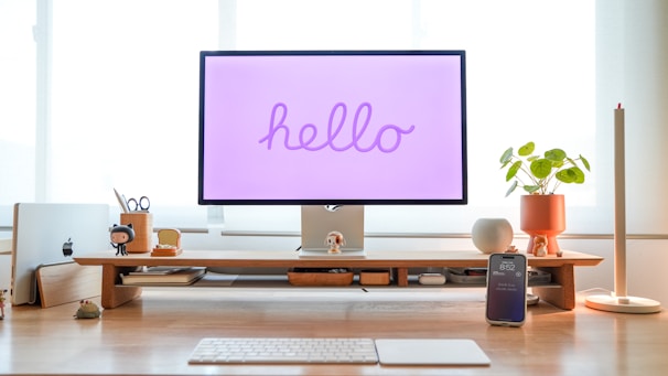 A modern workspace with a glowing AI assistant hologram interacting with a user.