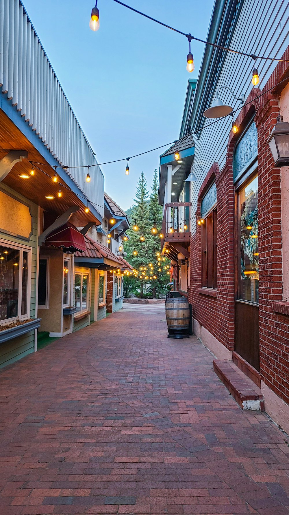 a brick street lined with buildings and lights
