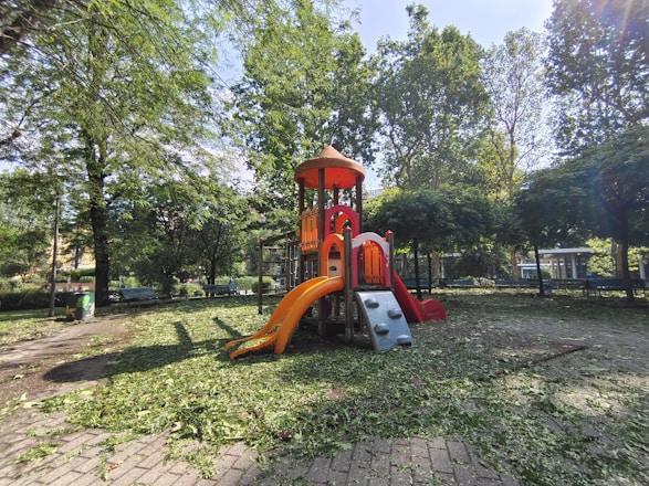 Children happily playing outside in a safe, green playground after school.