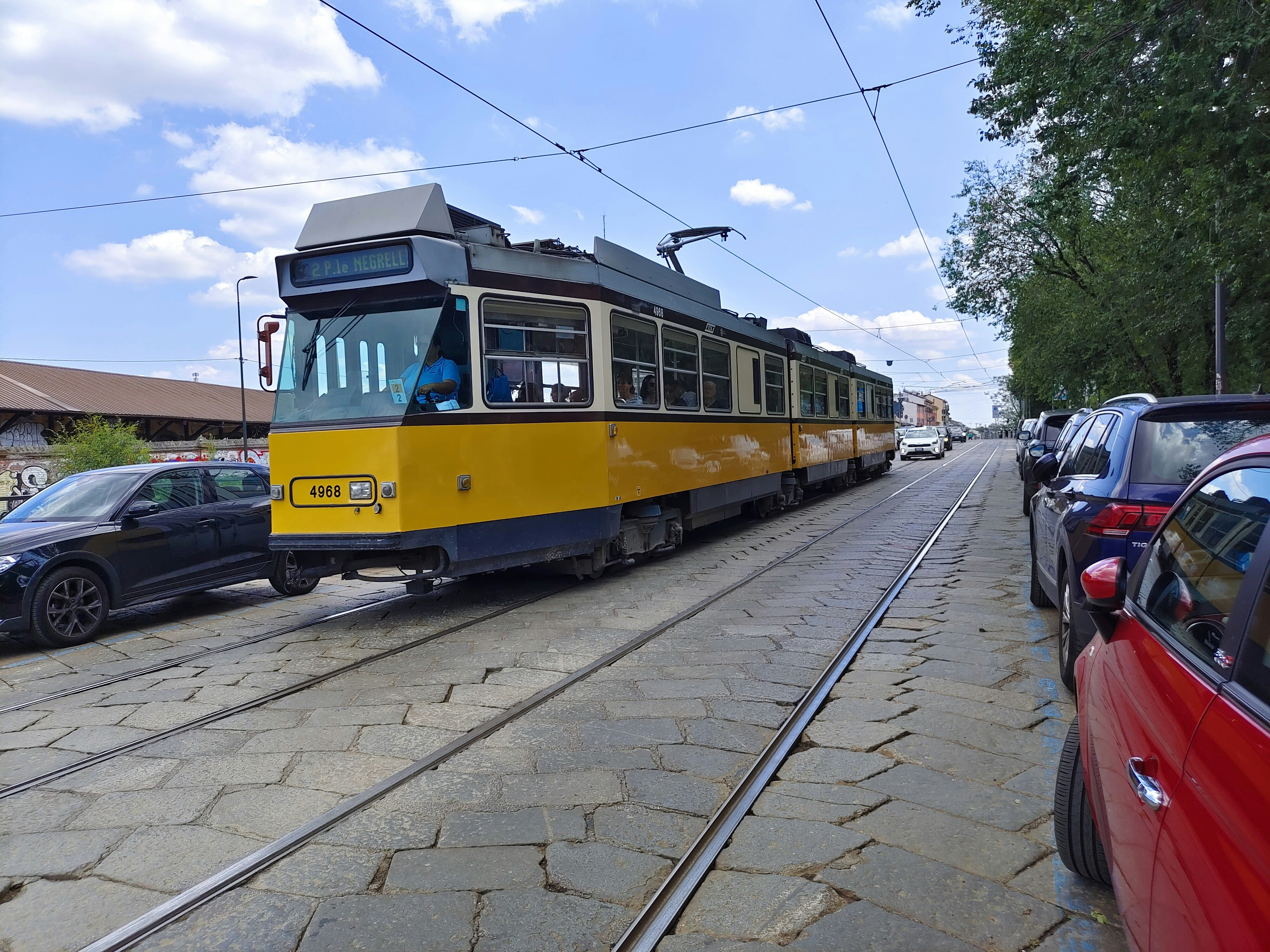 a yellow and blue trolley car on a street, 