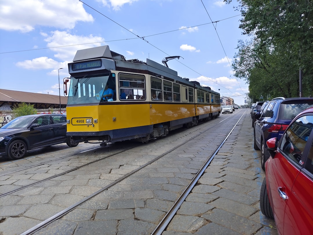 a yellow and blue trolley car on a street,