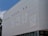 A building facade features a series of four comic strip panels depicting a cartoon character talking about a new diet involving doughnuts. The panels are aligned horizontally across the exterior wall. The artwork is in black and white, with the comic character prominently featured.