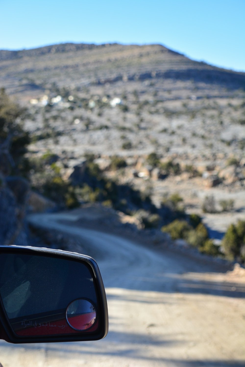 a view of a dirt road from a car window