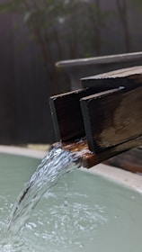Elegant faucet with water gently pouring into a white ceramic basin.