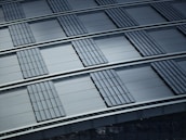 A pattern of overlapping metallic panels creates a structured and orderly composition. The panels have a corrugated texture that adds depth and dimension. The overall impression is of industrial design with precise alignment and repetitive shapes.