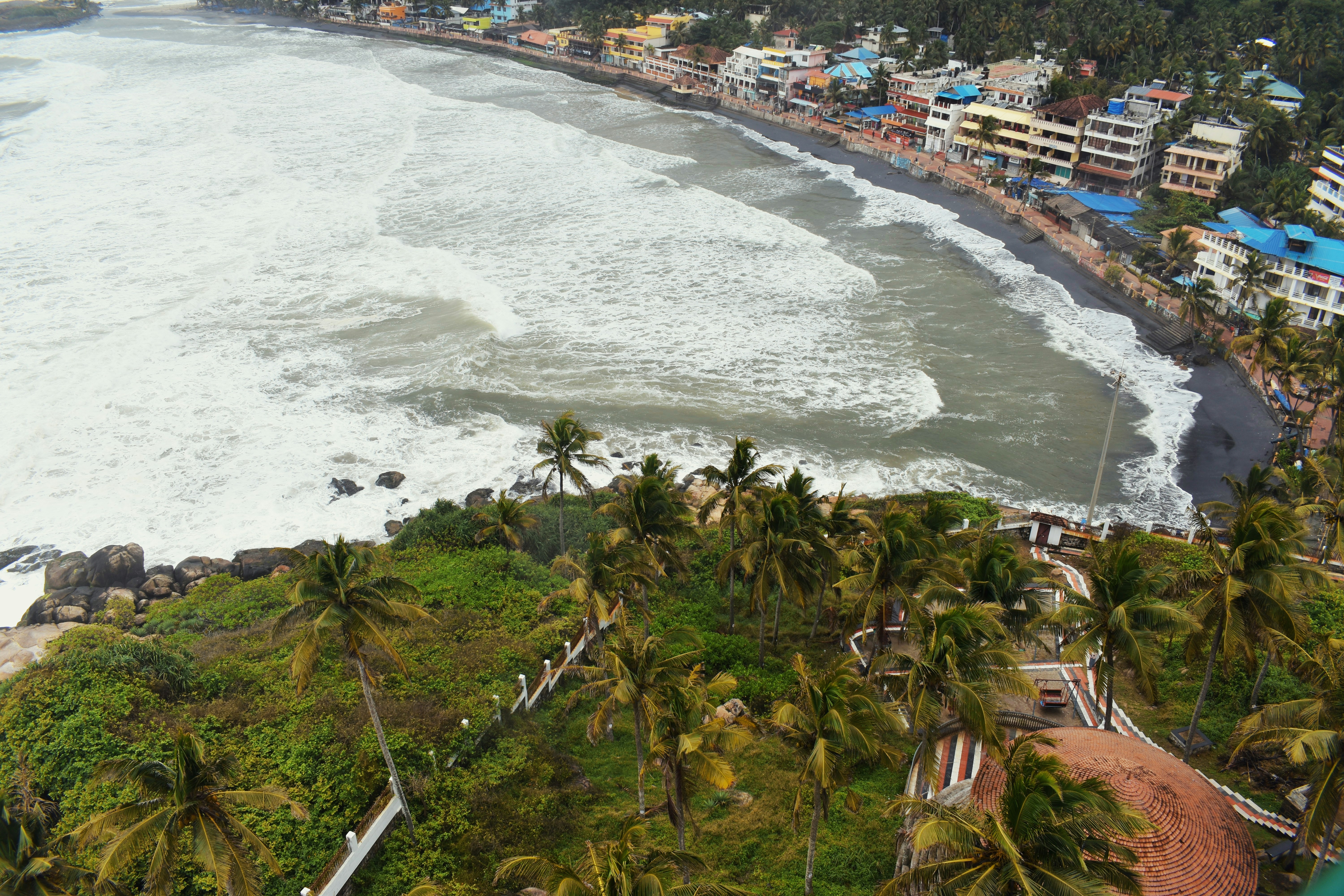 an aerial view of a beach with houses on the shore