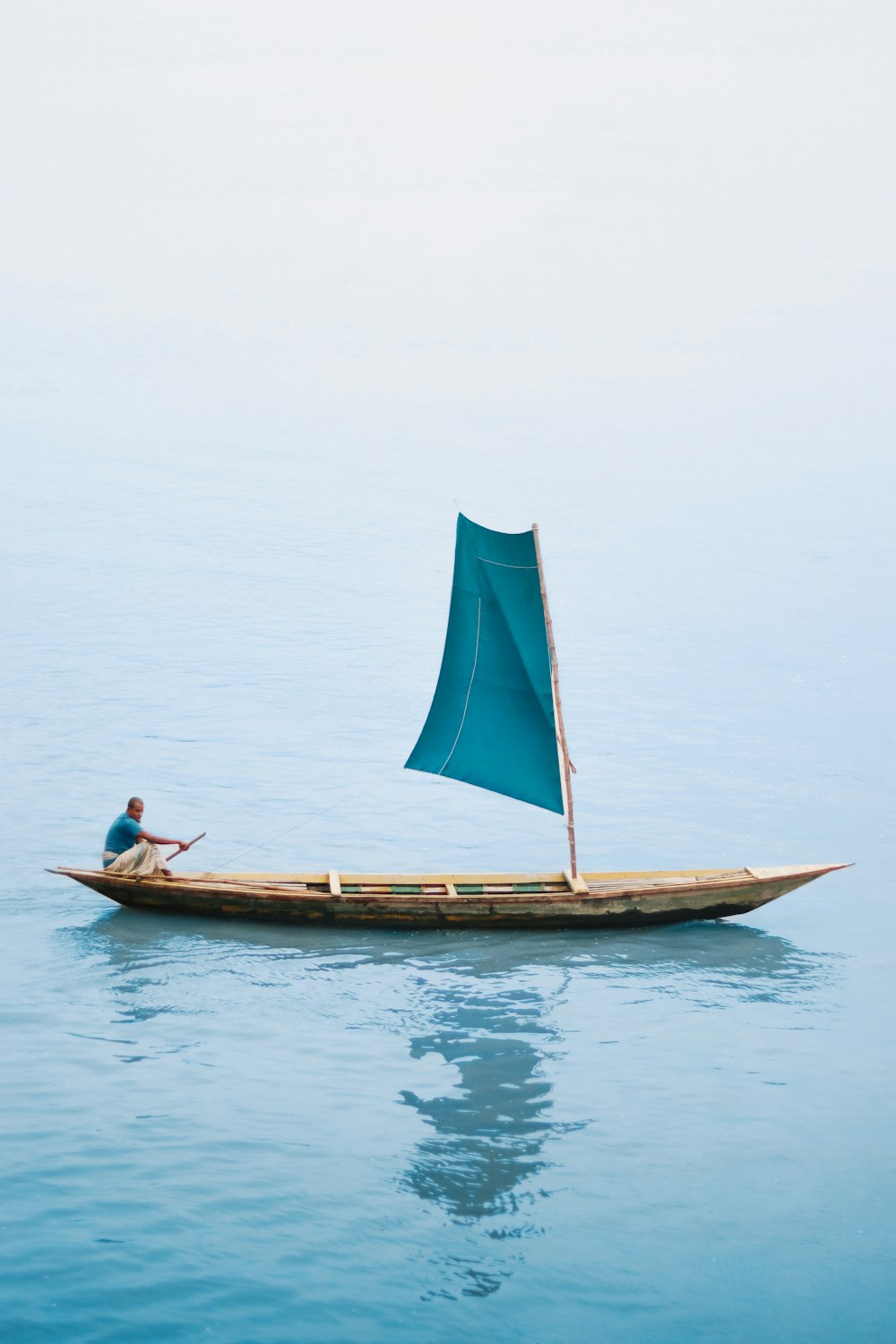 a man is sitting on a small boat in the water